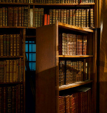 Eine Geheimtür in einem Bücherregal, die einen Spalt geöffnet ist