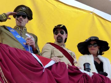 Der General und das Pr�sidentenpaar (alle 3 von M�nnern gespielt) verfolgen die Ankunft der G�ste von der Br�cke (Hausterrasse)aus